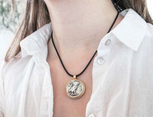 Woman wearing an Ancient Greek silver coin necklace stamped with Athena and an Owl, set in 14k gold