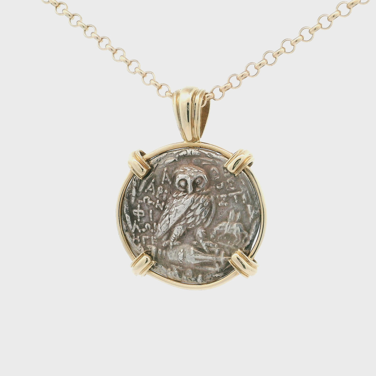 Rotating Silver Ancient Greek coin pendant set in 14K gold.