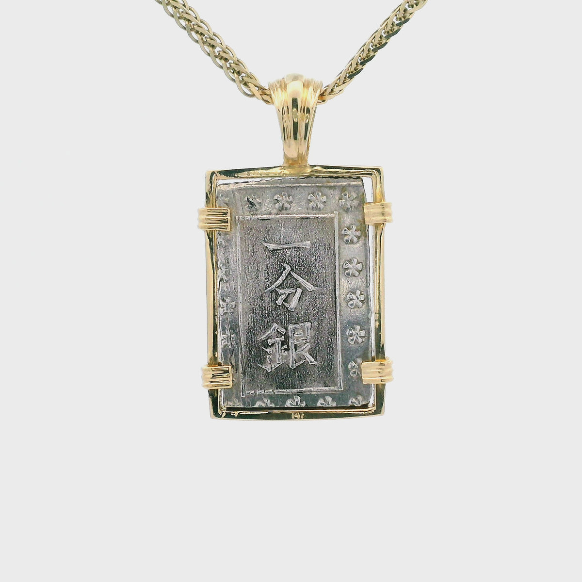 Rotating Silver rectangular Japanese Samurai-era coin pendant set in 14K gold.