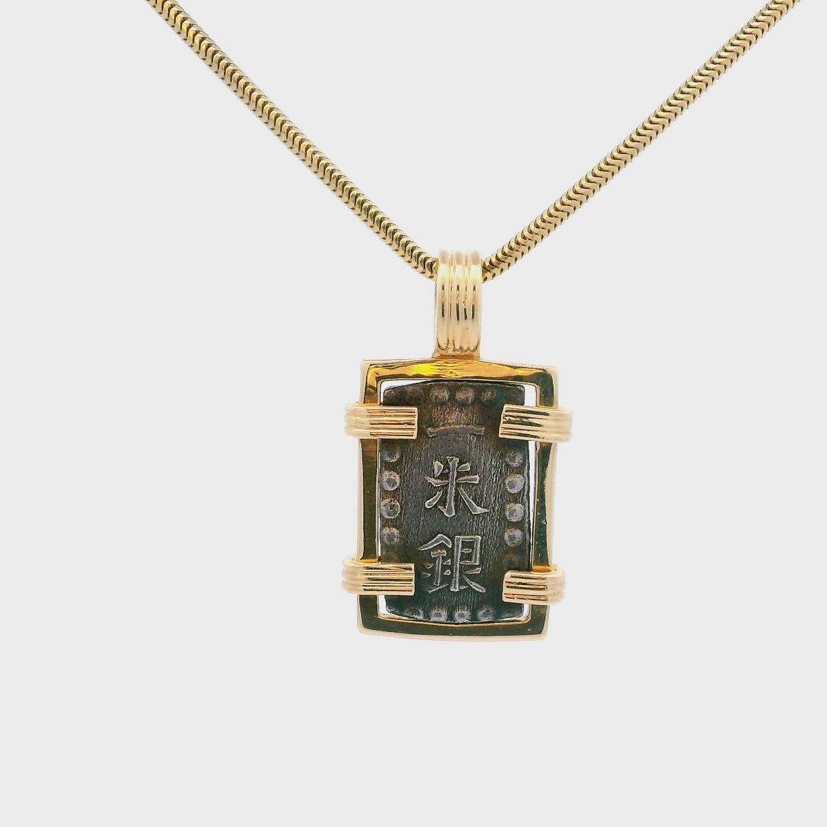 Rotating Silver rectangular Japanese Samurai-era coin pendant set in 14K gold.