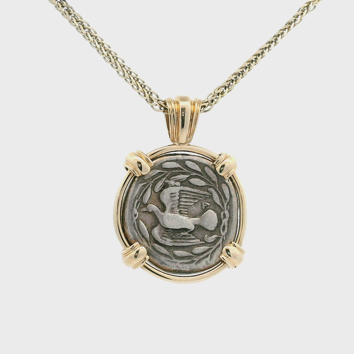 Rotating Silver Ancient Greek coin pendant set in 14K gold.