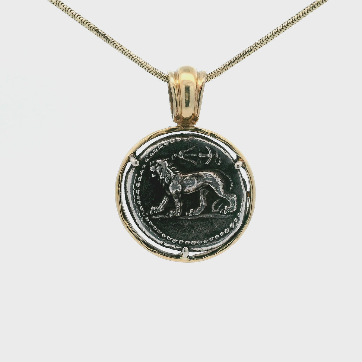 Rotating Silver Ancient Greek coin pendant set in 14K gold.