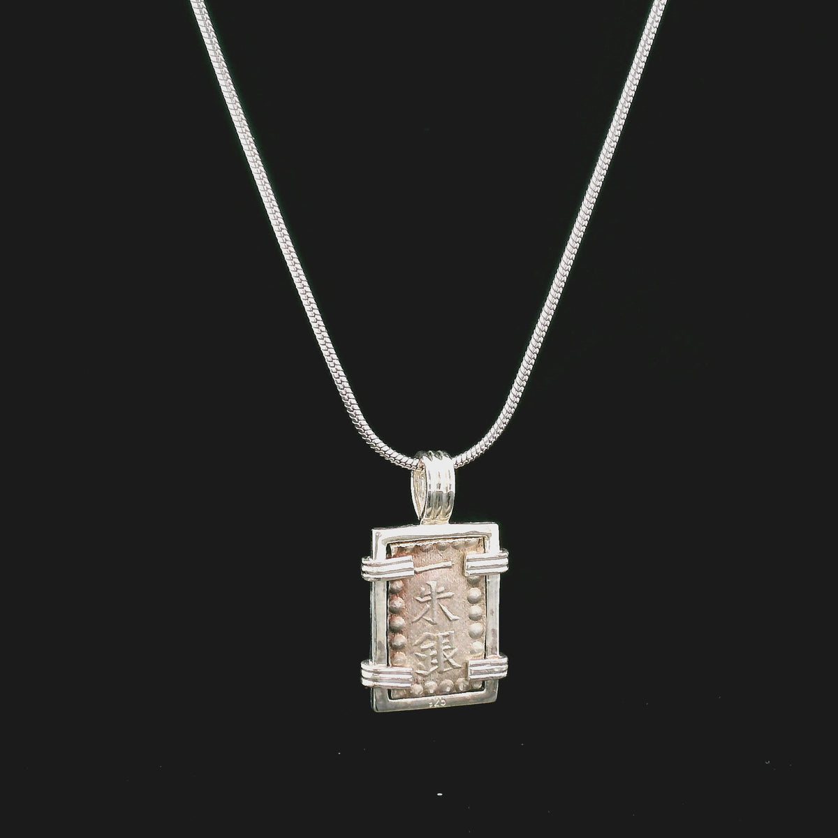 Rotating Silver rectangular Japanese Samurai-era coin pendant set in sterling silver.