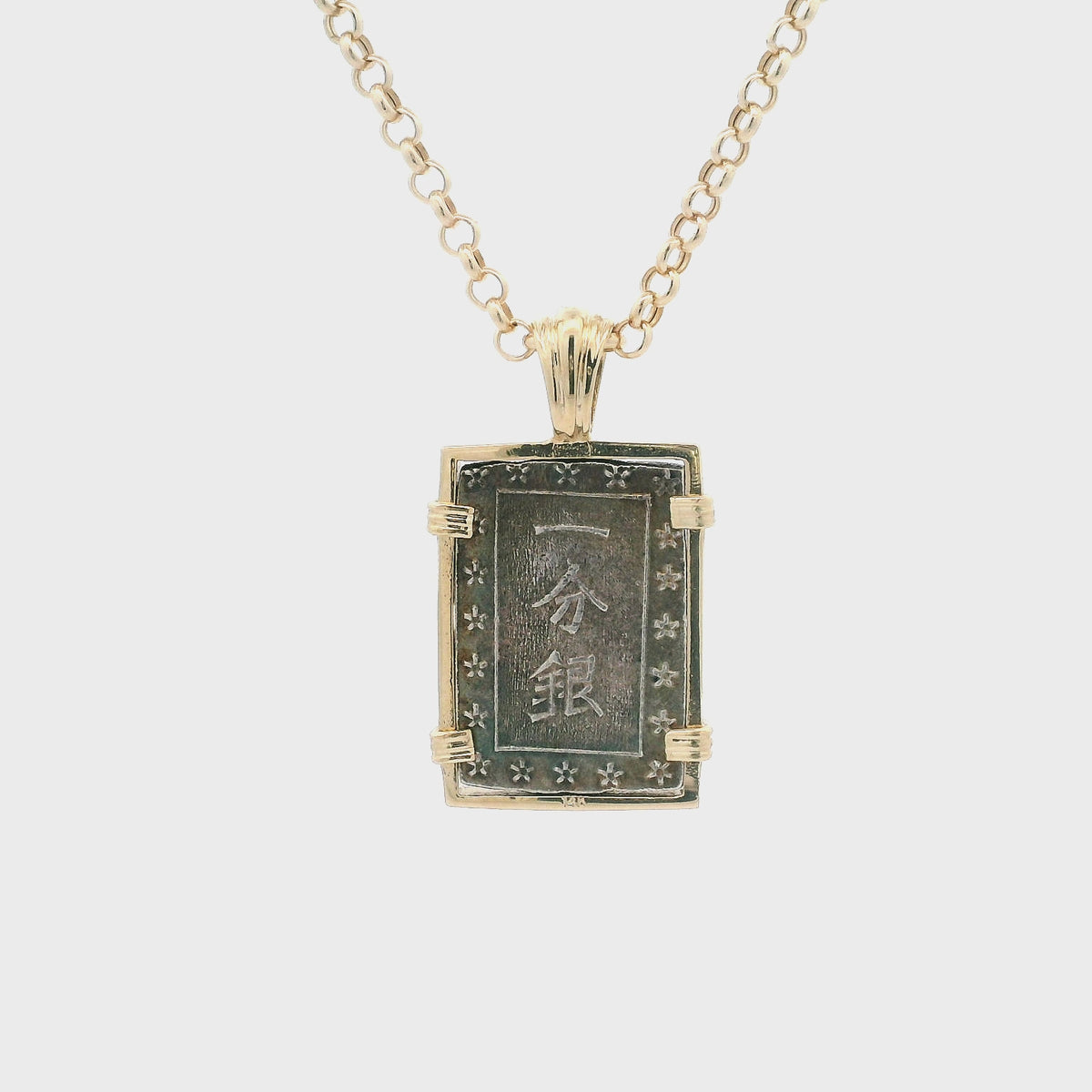 Rotating Silver rectangular Japanese Samurai-era coin pendant set in 14K gold.