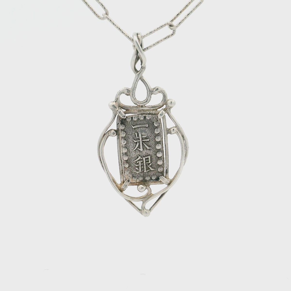 Rotating Silver rectangular Japanese Samurai-era coin pendant set in sterling silver.