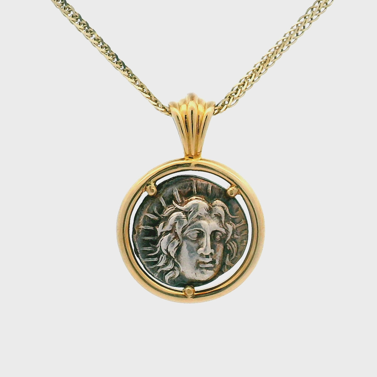 Rotating Silver Ancient Greek coin pendant set in 14K gold.